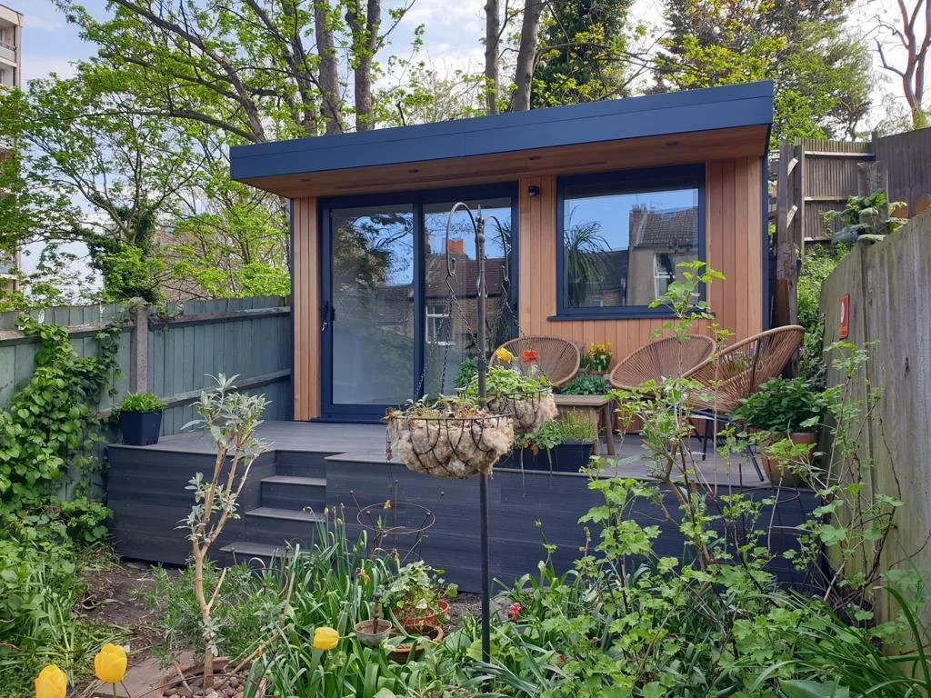 Cedar-clad garden room with glazed doors in a landscaped garden