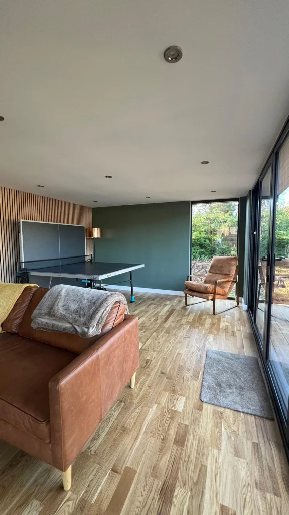 Games room interior with a pool table and feature wall