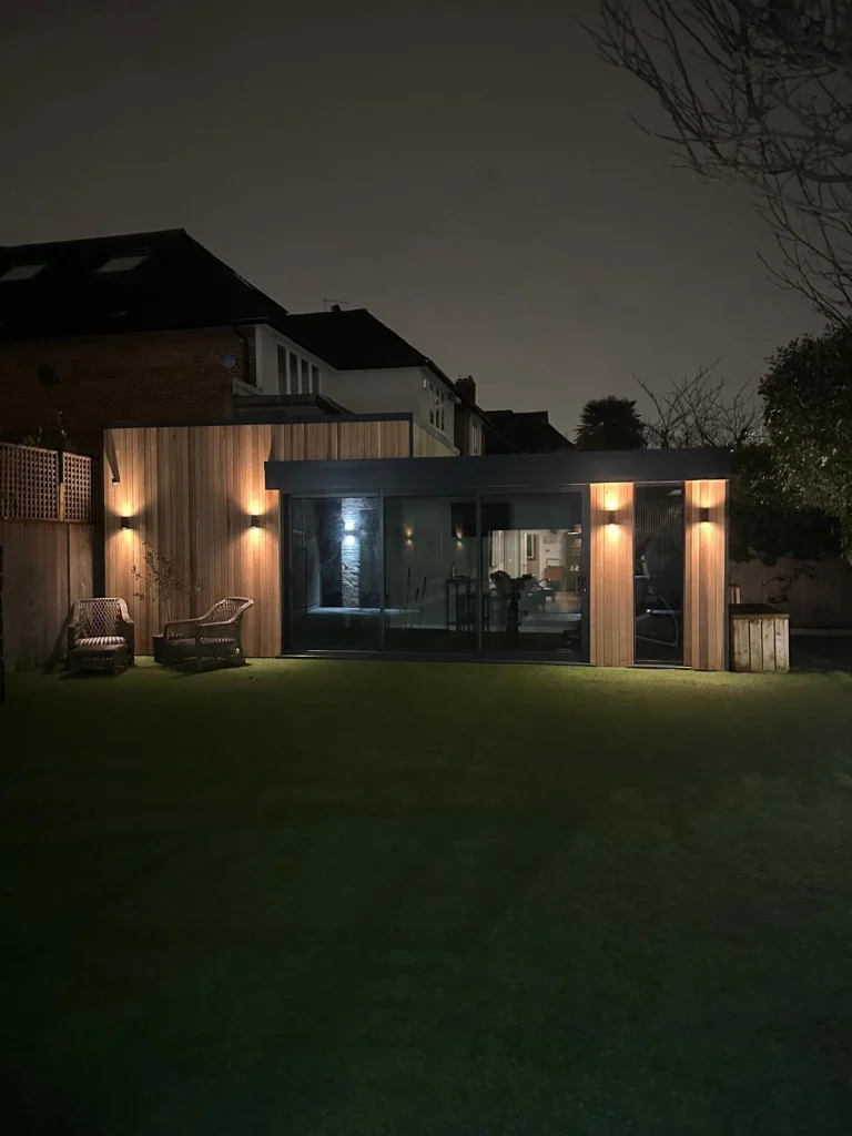 Garden room lit from inside at dusk
