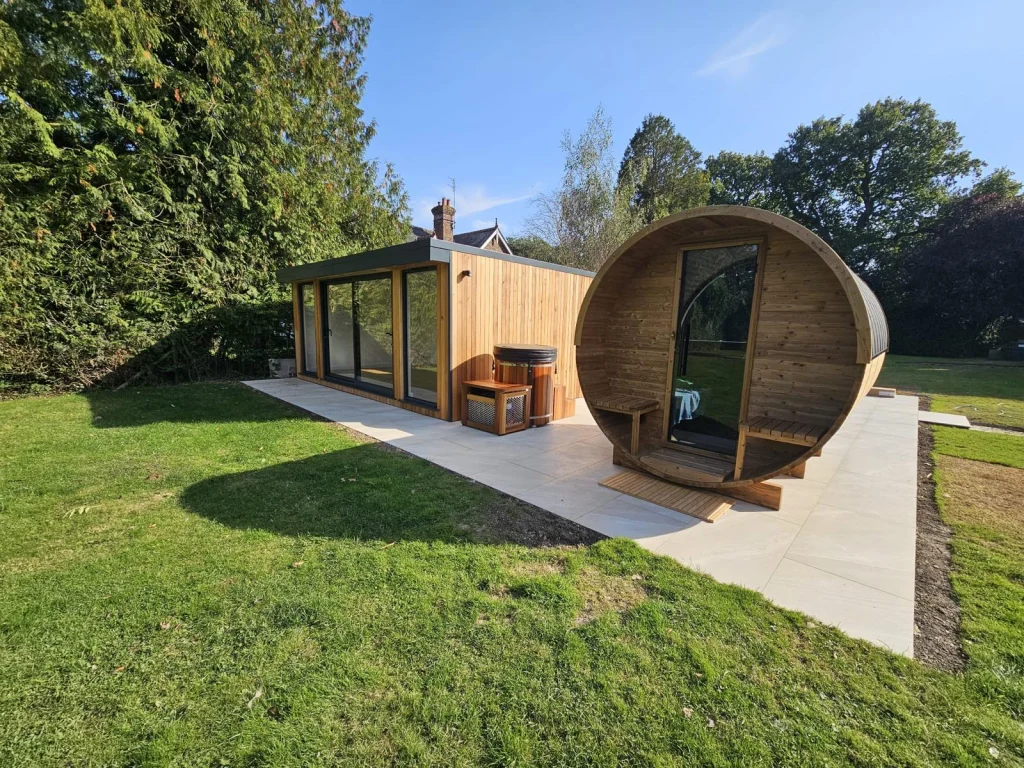 Garden room with a barrel sauna beside it