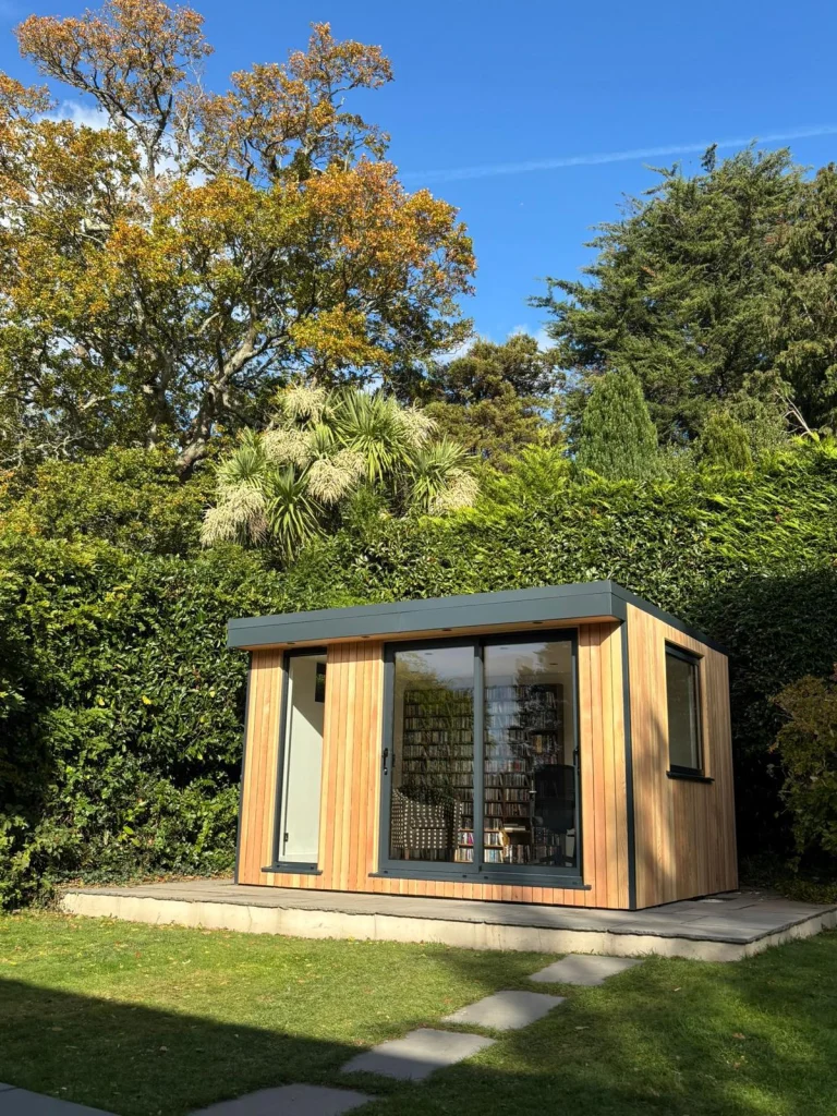Wood-clad garden room set among established trees