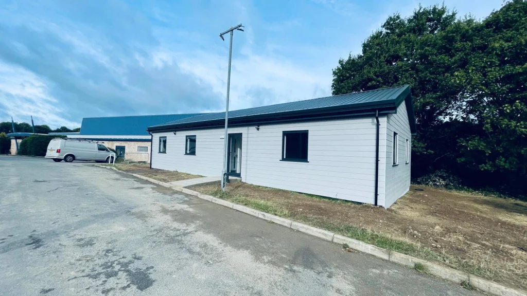 Grey modular building with glazed frontage and external access steps