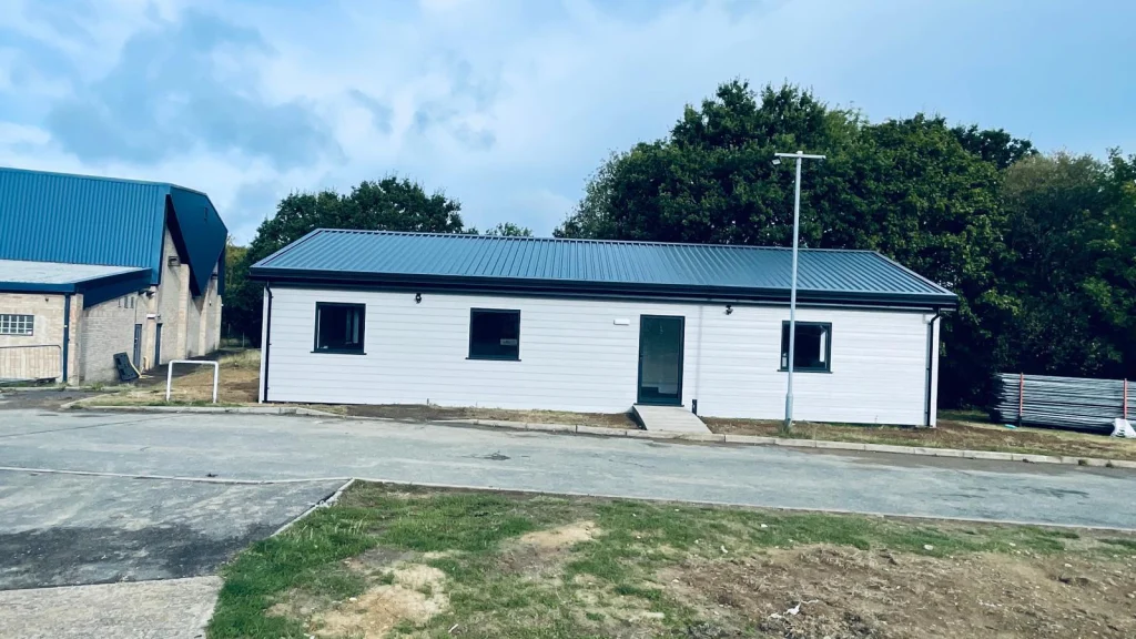 Modular building with charcoal cladding set in landscaped grounds